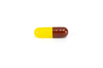Yellow and brown herbal medicine capsule. For concepts of natural supplements, vitamins, turmeric, or fish oil. isolated on white background with clipping path.