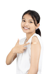 Happy Asian girl smiling and pointing to a bandage on her arm after receiving a vaccine. Concept of successful, safe, and positive child vaccination.