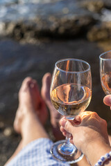Wine in hands of woman against sea background. Selective focus.