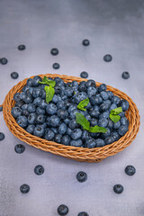 Hanging basket filled with blueberries, photographed outdoors against a nature background for a fresh, organic style