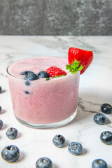 Blueberry and coconut smoothie served in a glass, with a rustic wood background and soft morning light