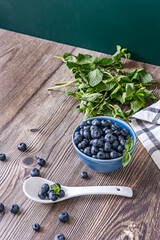 Blueberries in a stainless steel bowl, reflecting the light and giving a modern and industrial touch to the composition