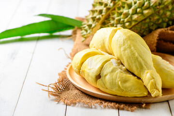 Durian fruit. Ripe monthong durian on sack and white wood background, king of fruit from Thailand on summer