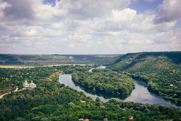 Obraz premium A stunning river winds gracefully through a dense forest, forming a perfect heart shape at its center. Surrounded by lush greenery. 