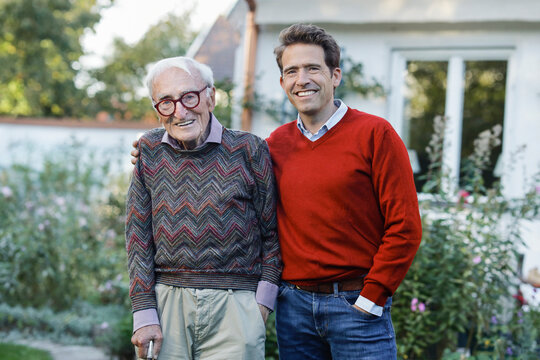 Happy father and son standing at backyard