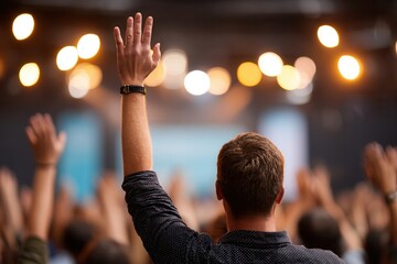 Rear view of young caucasian male raising hand at indoor event.