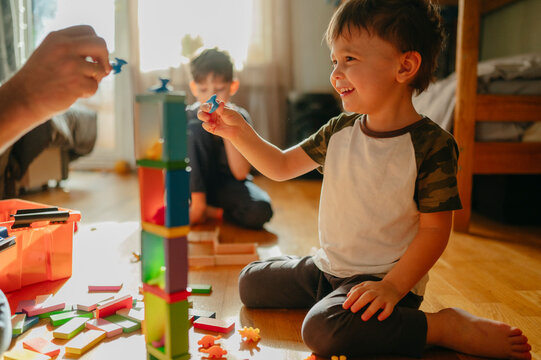 Smiling boy playing games with father at home