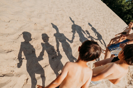 Man walking on sand with children