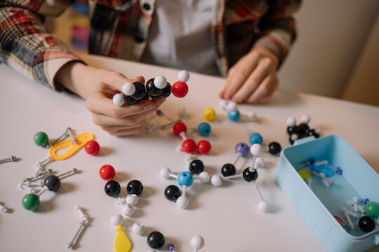 Teenage boy studying atom molecular structure at home