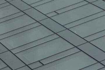 Fototapeta premium Here is a closeup view of a beautiful gray tile roof that features an interesting and intricate diagonal pattern, enhancing its visual appeal