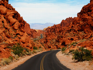 Tarred road cutting through the vivid dark red rocks of the Valley of fire State Park in Nevada