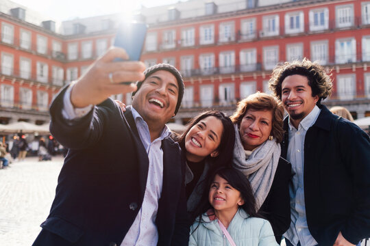 Happy man taking selfie with family near Casa de la Panaderia building, Madrid, Spain