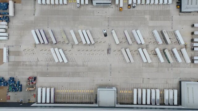 Aerial drone footage of huge distribution centres centers and warehouses, industrial business park with heavy goods trucks and trailers economics import and export hub in England UK 