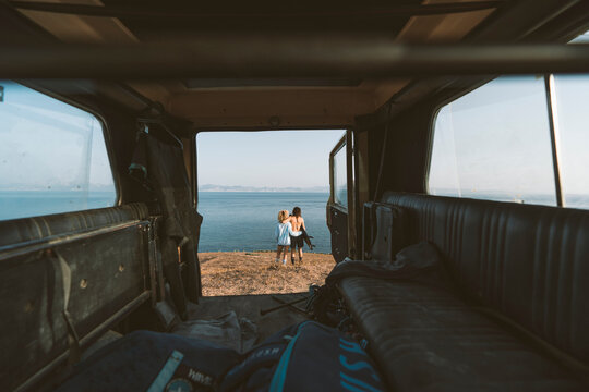 Couple admiring view while standing with arm around at beach