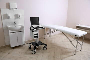 Modern ultrasound machine, sink and examination bed in clinic
