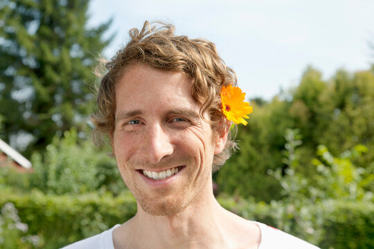Germany, Hamburg, Man wearing marigold in allotment garden