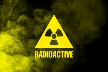 Radioactive sign and yellow toxic smoke against black background