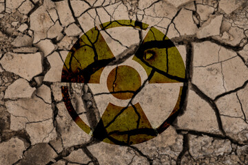Radioactive sign on cracked dry earth, top view. Radiological pollution