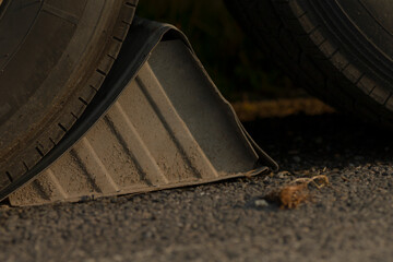 This image features a closeup view of a wheel chock positioned on the ground right next to a tire, emphasizing its function and importance in vehicle safety