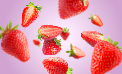 Yummy fresh strawberries swirling in air against violet background