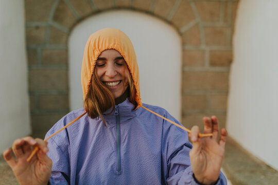 Smiling woman with eyes closed wearing windbreaker jacket