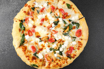 Whole vegetable pizza on dark stone background for fast food, restaurant menu or italian cuisine concept