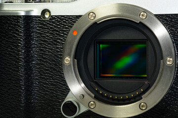 Close-up shot of a mirrorless camera body with the lens removed, revealing the image sensor inside.