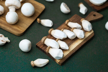 Assorted mushrooms on boards with dark green background for harvest variety or vegetarian cooking...