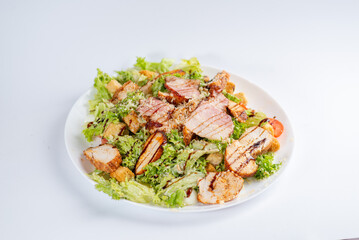 Caesar salad with chicken on a white plate