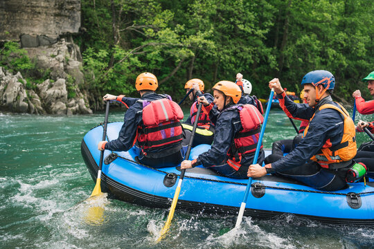 Group of people rafting in rubber dinghy on a river