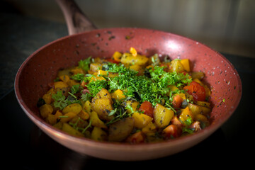 ready to eat - roasted potatoes with herbs from the garden, cherry tomatoes and paprika