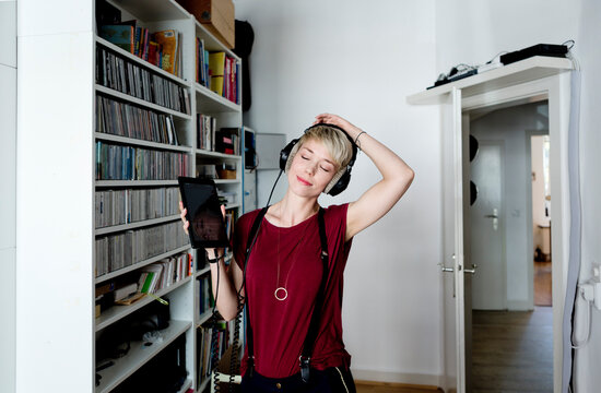 Woman listening to music with headphones at home