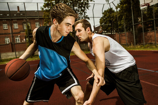 Two young basketball players at duel