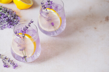 Homemade lemonade presented with lavender, lemon slices and bubbles creating a refreshing ambiance. Delicate lavender sprigs enhance the drink's visual appeal. Detox and vegan beverage. top view
