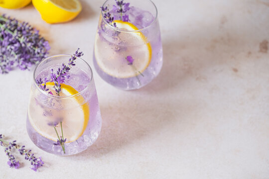 Homemade lemonade presented with lavender, lemon slices and bubbles creating a refreshing ambiance. Delicate lavender sprigs enhance the drink's visual appeal. Detox and vegan beverage. top view