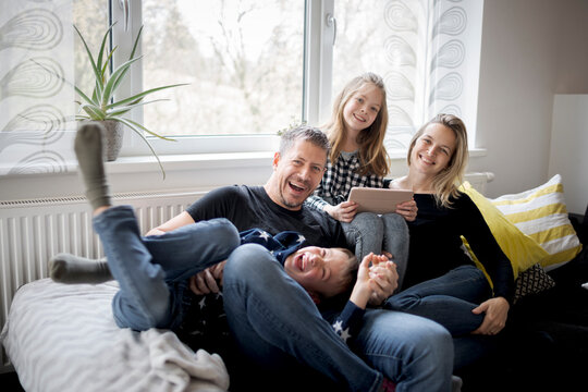 Portrait of happy family having fun on couch at home