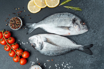 Close up of fresh raw dorado fish with rosemary on black background
