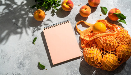 Summer flat lay on a concrete background Peach notepad and an eco-friendly mesh shopping bag