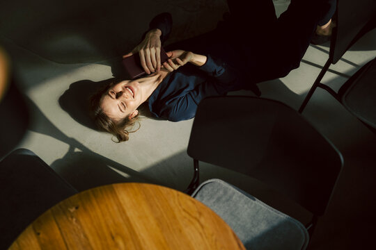 Woman relaxing on the floor in a caf� during a break from remote work