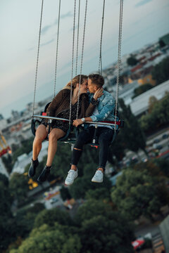 Young couple in love, riding chairoplane on a fairground