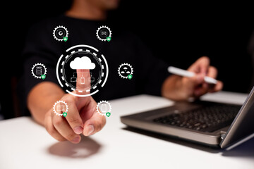 A person interacts with a virtual cloud computing interface while using a laptop and stylus, symbolizing digital data management and technology.