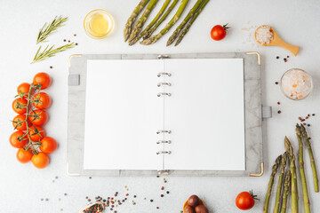 Blank recipe book with cooking ingredients on white background