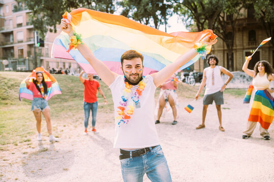 Young man with flag in pride event at park