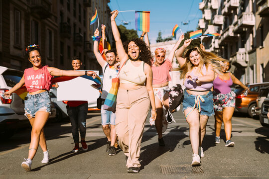 Cheerful female and male activists protesting for equal rights on street during sunny day