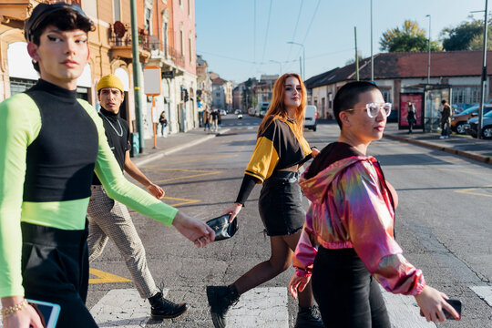 Friends walking on zebra crossing in city
