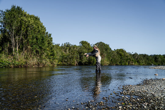 Woman Fly Fishing in River with Rod and Waders