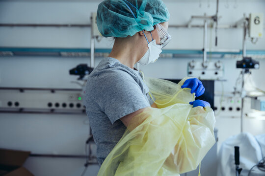 Doctor taking off personal protective equipment in hospital