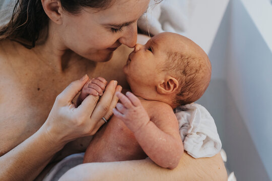 Smiling mother rubbing nose with son in bathtub at home