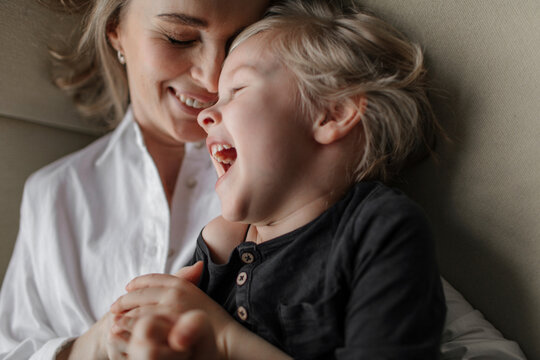Close-up of blond boy enjoying leisure time with mother at home