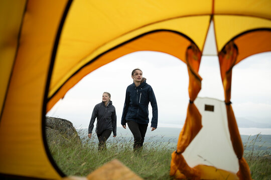 Two women camping in North Wales, UK, seen through a tent opening